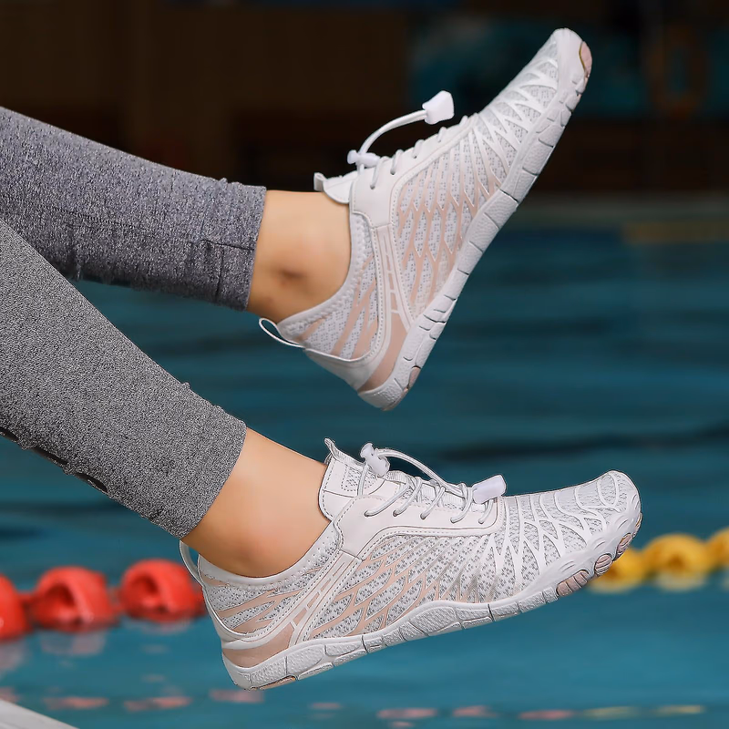 close up of white peak footwear shoes on a persons feet by a