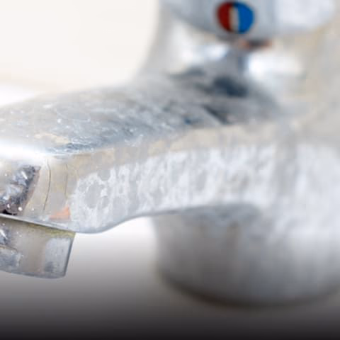 grime and hard water stains on a faucet