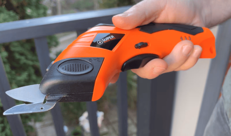 hand holding orange superscissor electric scissors