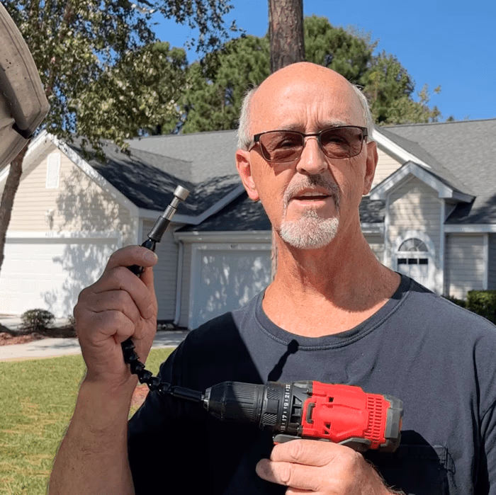 man holding superbit flexible shaft and power drill