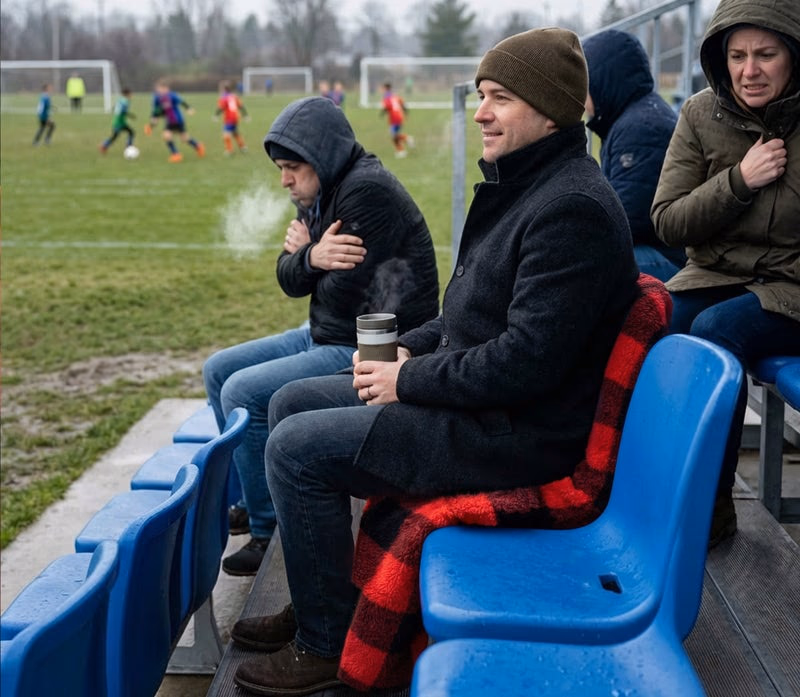 man uses chair blanket at outdoor soccer game