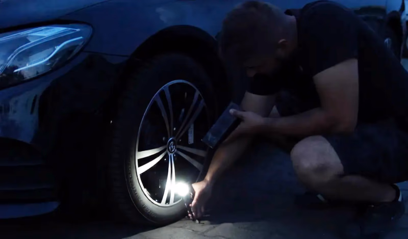 man using tirehero flashlight at night