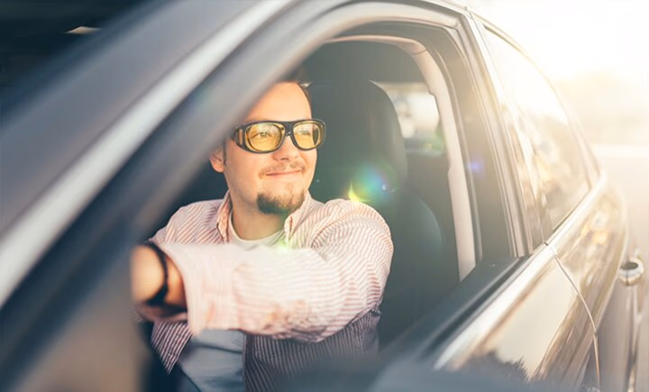 man wearing yellow driving glasses in car