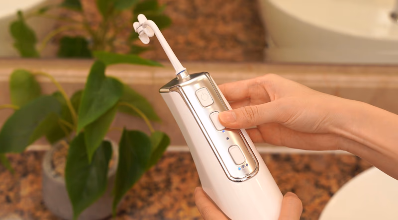 miracle smile water flosser held by hand