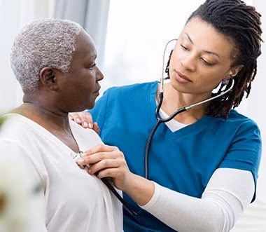 nurse examining an elderly patient with stethoscope