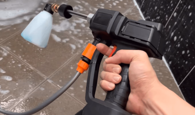 person holding foam cannon pressure washer for cleaning
