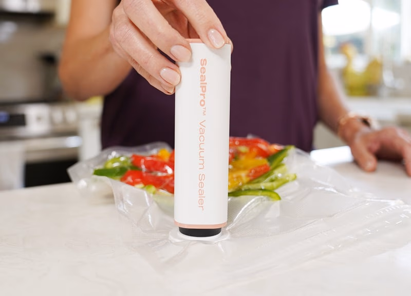 person using sealpro vacuum sealer on a bag of chopped bell
