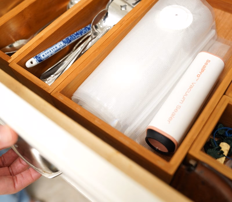 sealpro vacuum sealer and bags neatly organized in a kitchen
