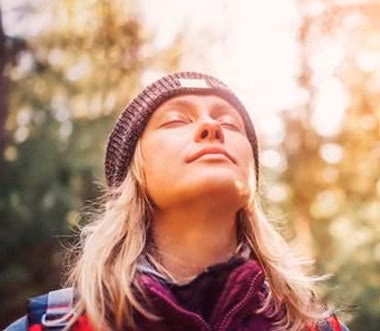 woman breathing deeply outdoors in nature