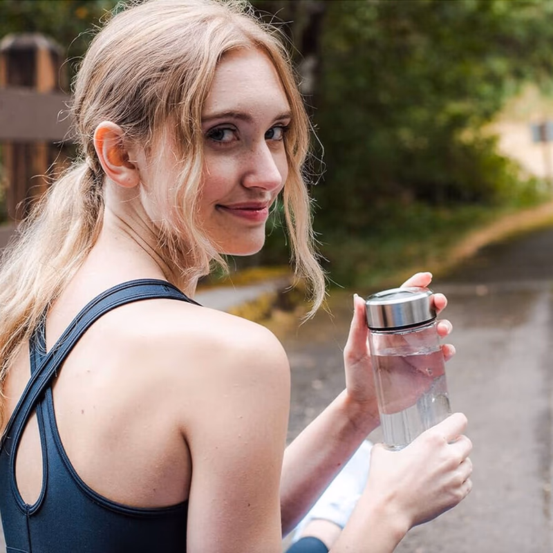 woman holding aquafusion bottle after workout